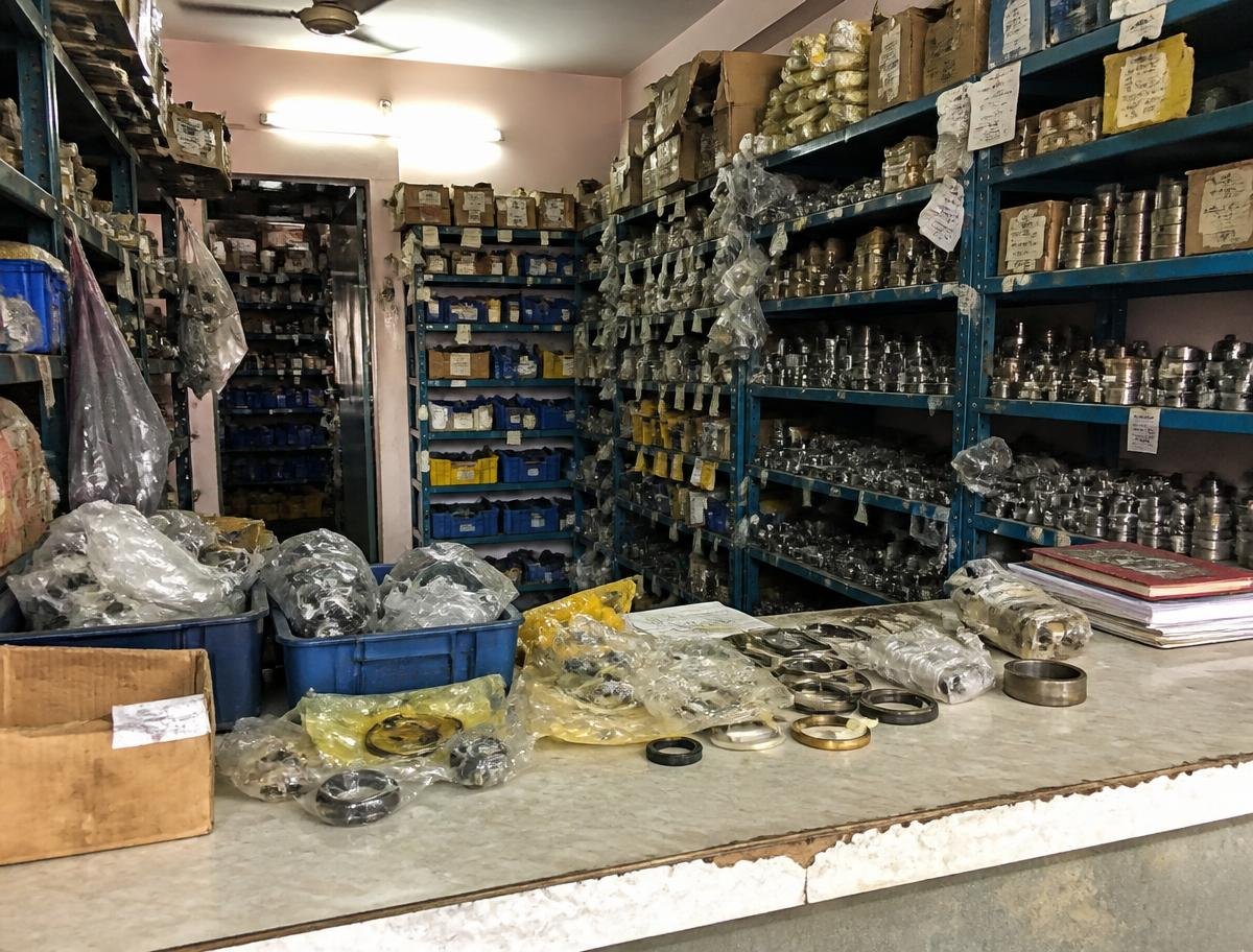 Cluttered earth-moving parts counter and stocked metal shelving in Chandigarh