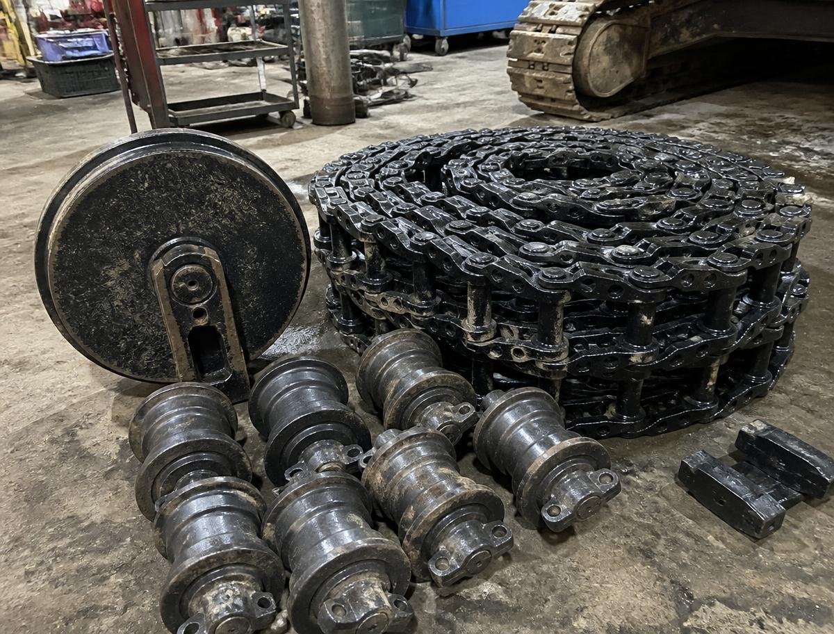Excavator undercarriage rollers, idlers and track chains in a workshop